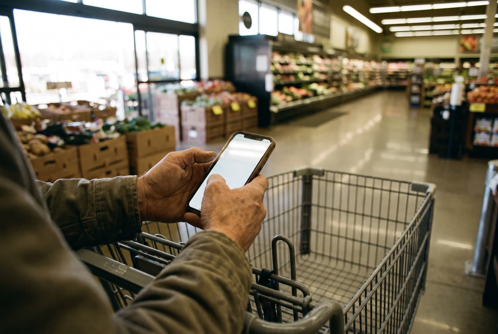 A shopper checking a written grocery list against the cart